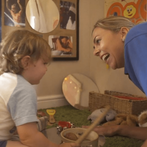 Childcare provider smiling at child