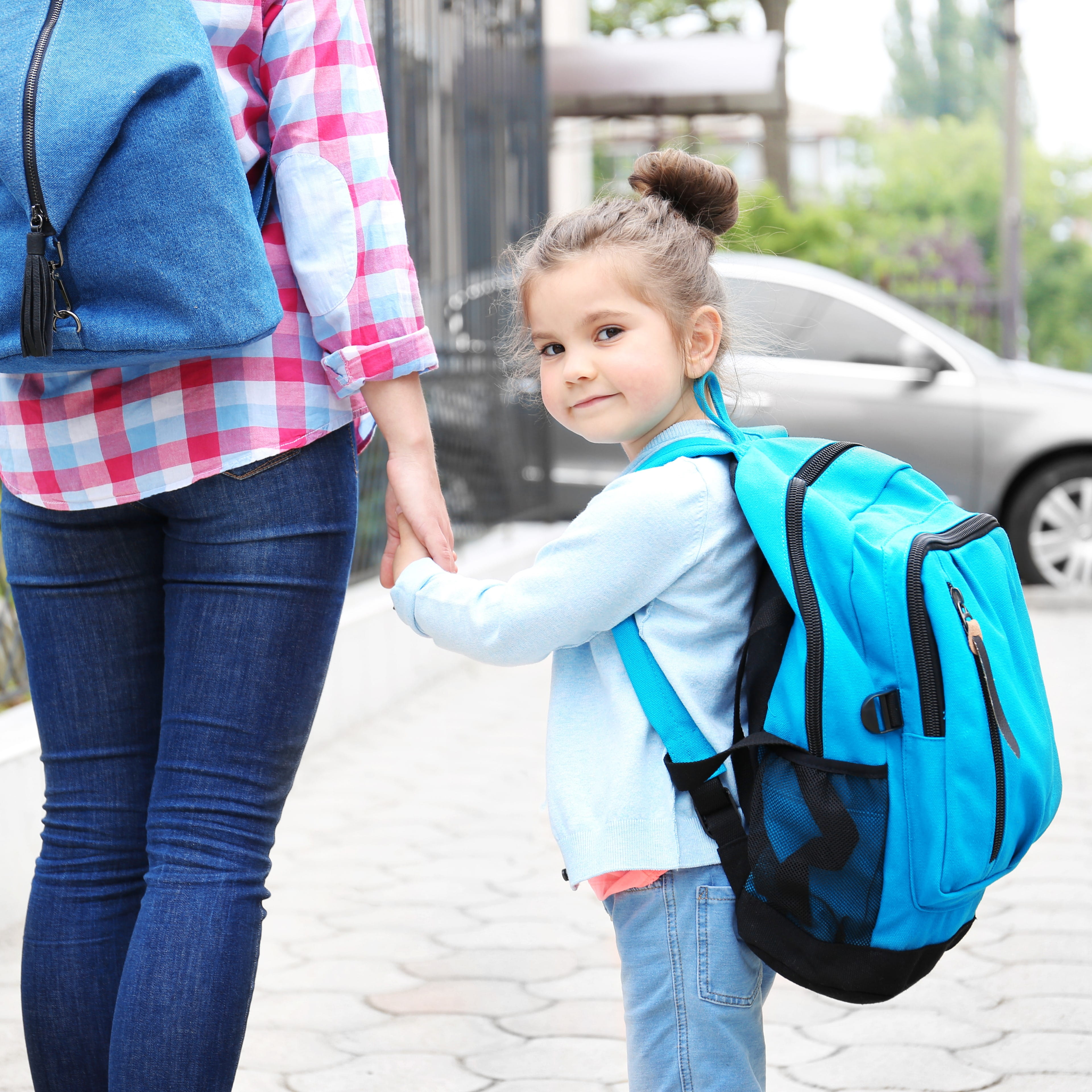 Child going back to nursery holding parent or carer's hand