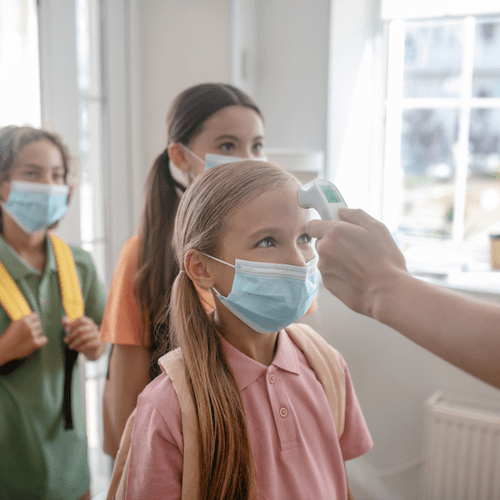 Image showing teacher checking children's temperature with a digital forehead thermometer