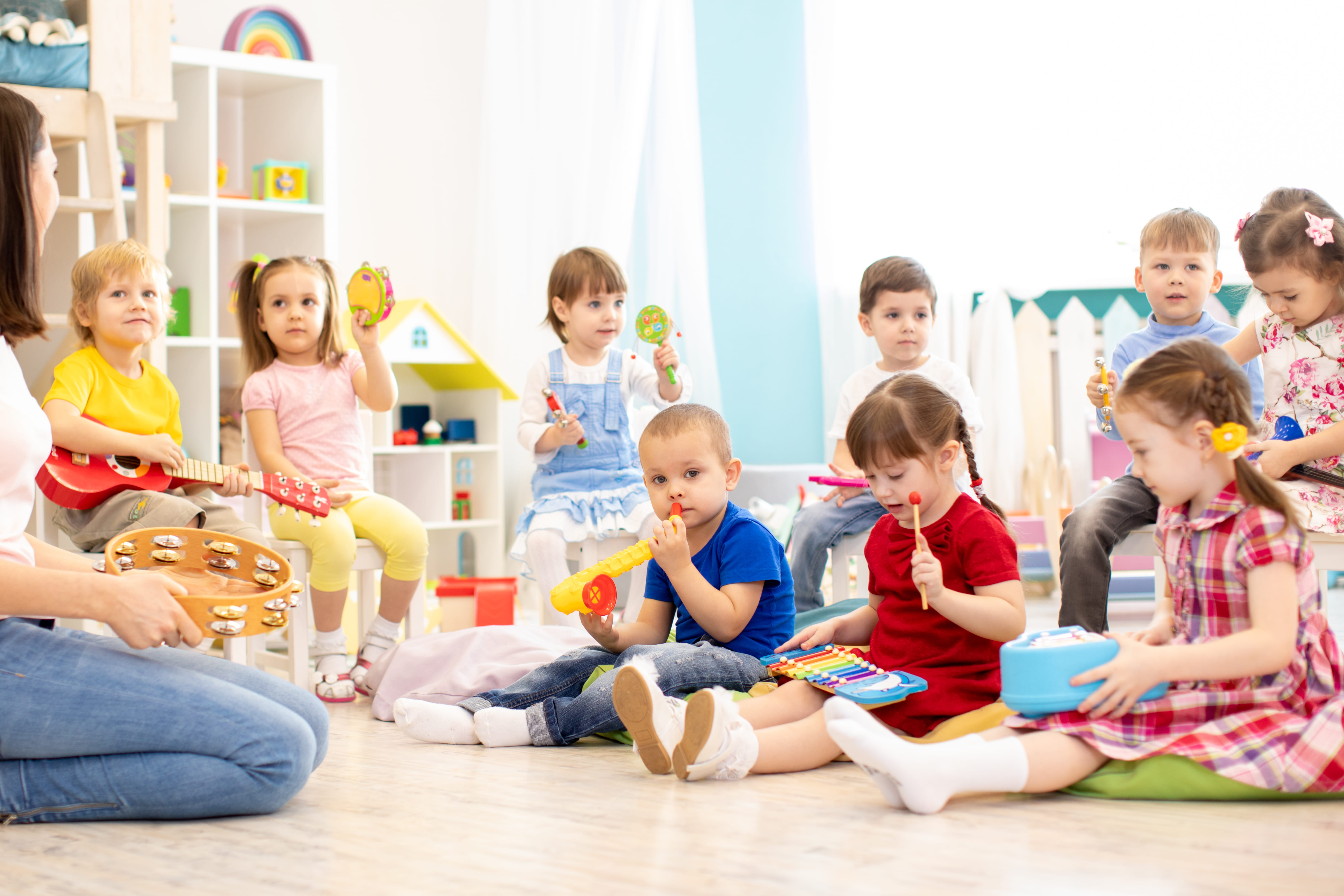 Group of kindergarten children play with musical toys. Early musical education in day care centre
