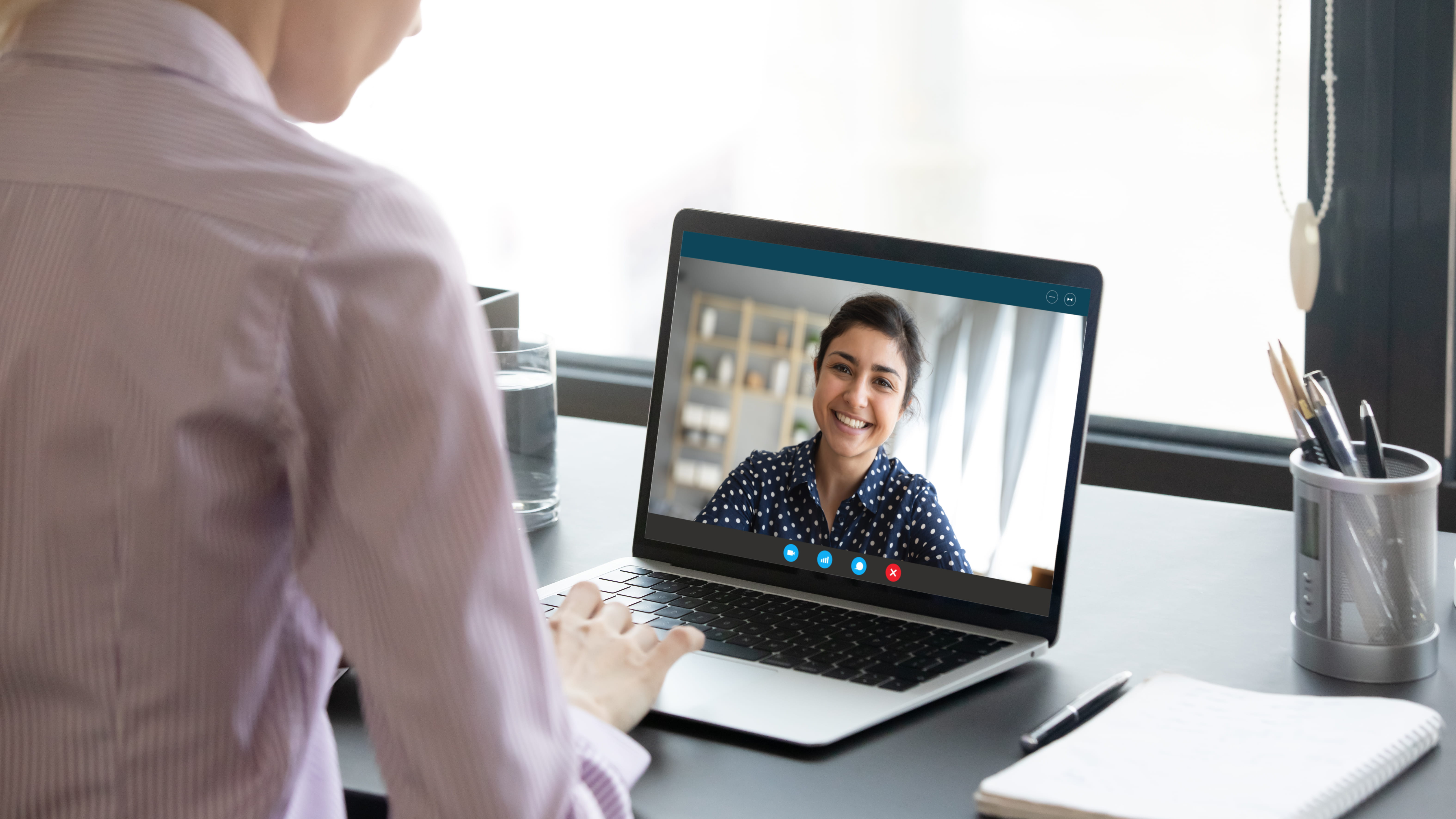 Lady smiling whilst partaking in virtual interview meeting on laptop