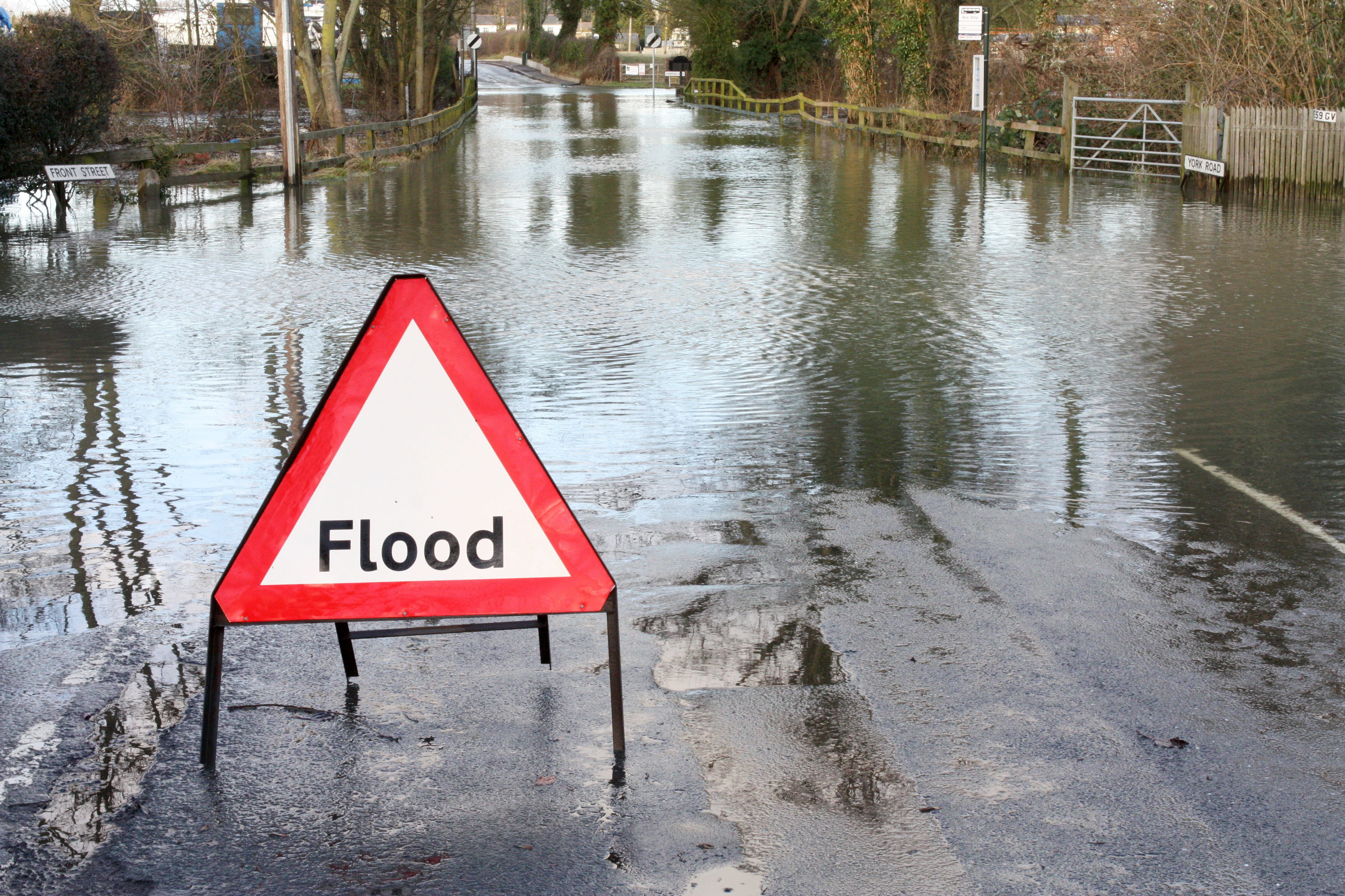 Road closed because of flooding with white and red flood road sign 