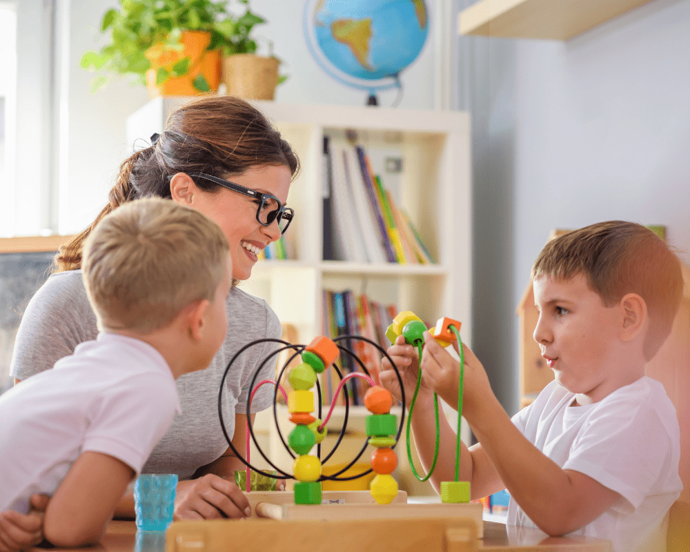 Preschool teacher with children playing with didactic toys