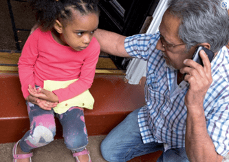 Adult comforting young child with a suspected broken bone in arm