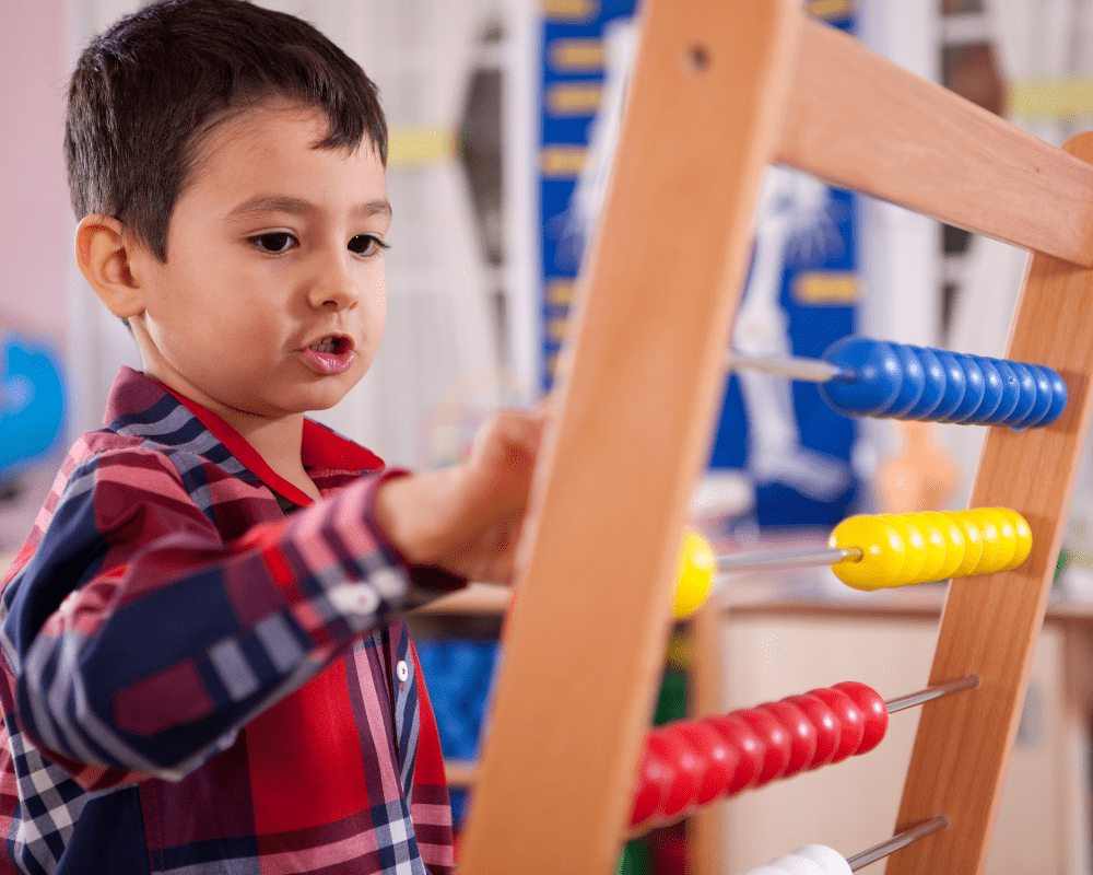 Little boy calculating with abacus 