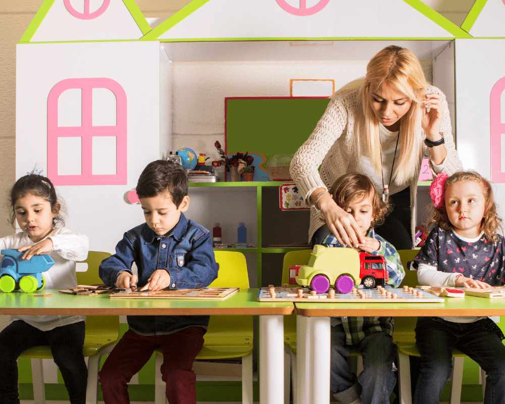 Preschoolers playing toys with teacher in classroom