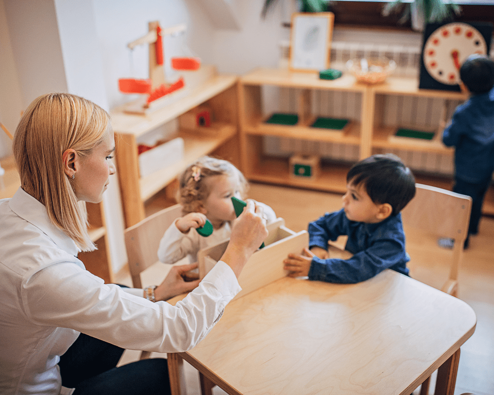 Teacher playing with children in their preschool classroom