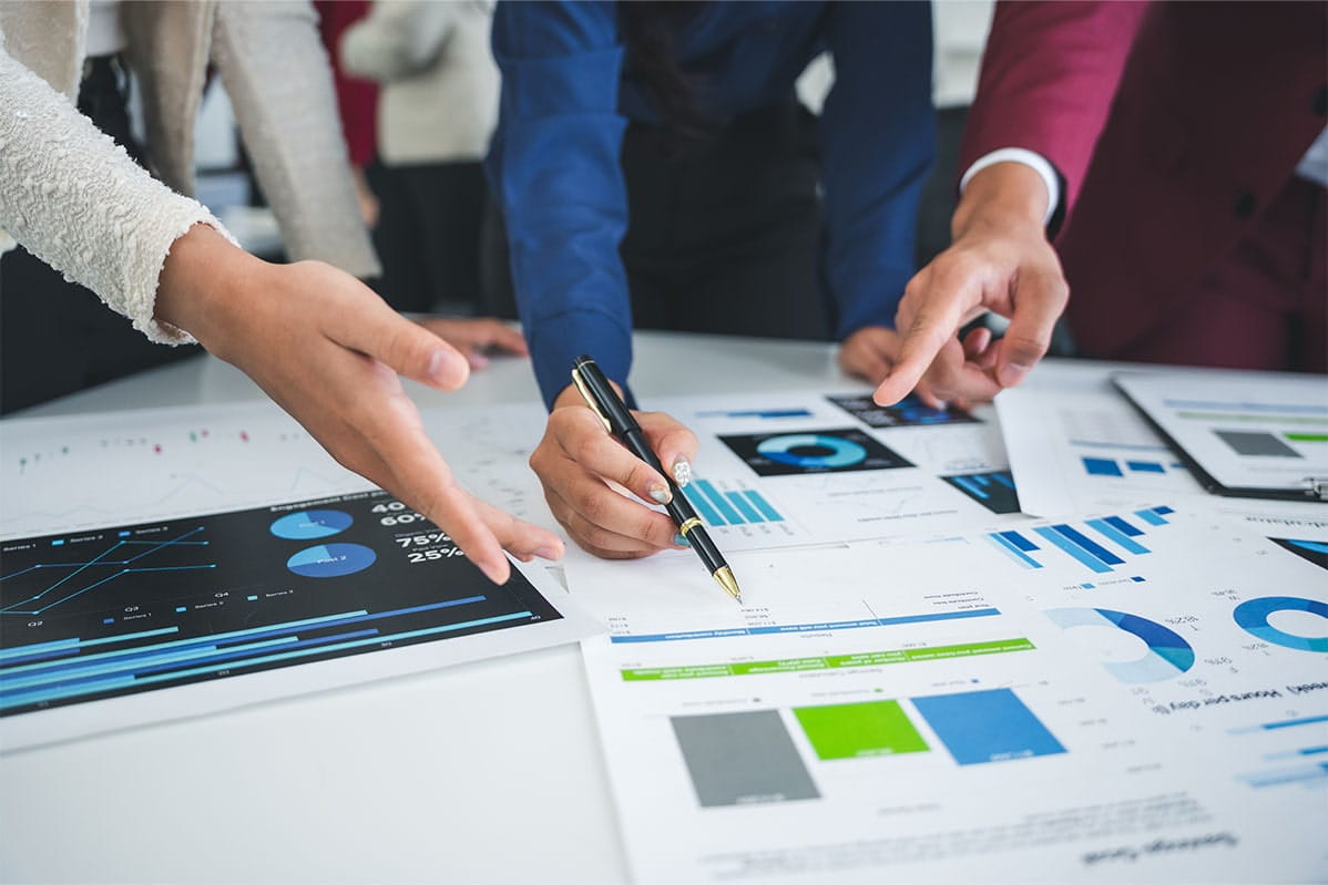 Businessmen and women in an office work together on a report