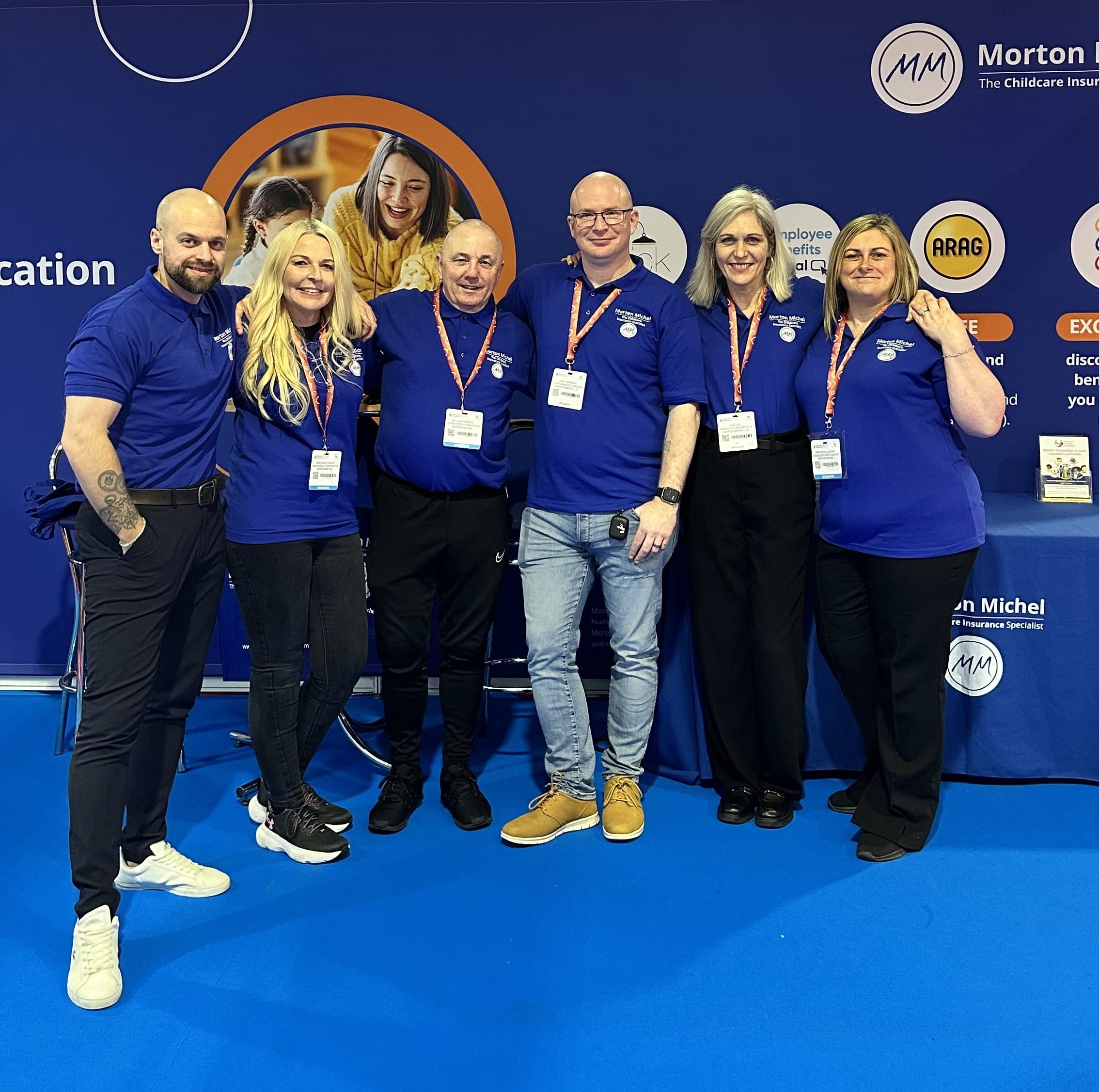Members of the Morton Michel team huddle together for a team photo on their stand at Childcare & Education Expo London 2025