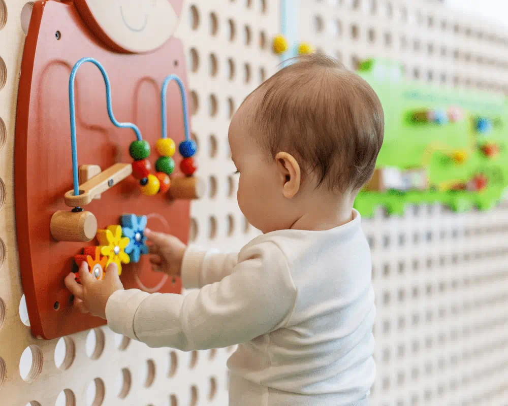 Toddler playing with activity wall 