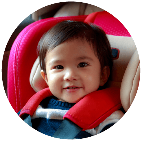 Baby girl sitting in car seat in the car, smiling