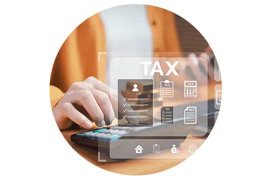 A self-employed woman wearing an orange cardigan calculates her tax on a calculator at her desk