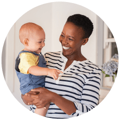 Smiling woman holding smiling baby in her arms