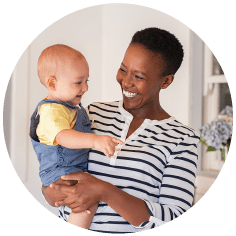 Smiling woman holding smiling baby in her arms 