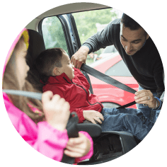Childcare professional putting on children's seatbelts