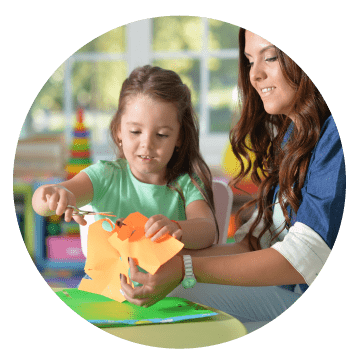 A child and their carer playing in a classroom or nursery setting.