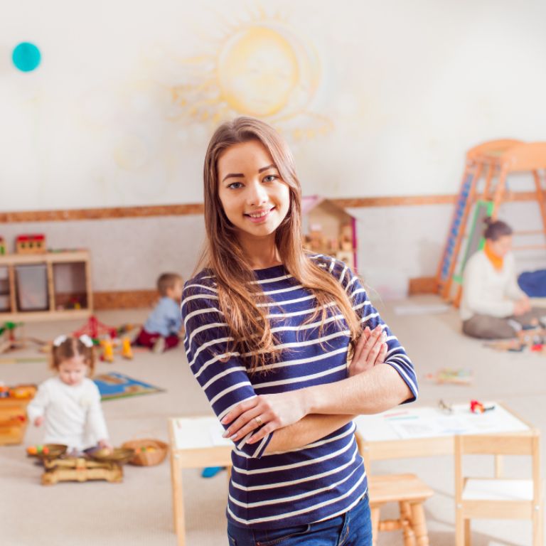 Young female teacher in nursery school room