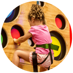 A child climbing a kid-friendly bouldering wall.