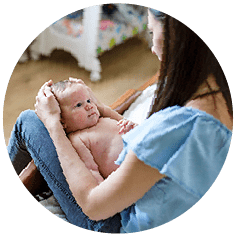 A photograph of a small baby on a parent or carer's lap.