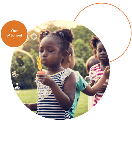 Children blowing bubbles outside with her friends.