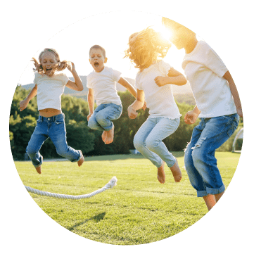 A group of children skipping in the sunshine.